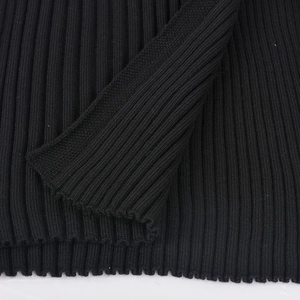Detailed macro view of black ribbed knit fabric showing the fine texture and quality weave