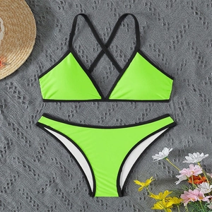 Detailed flat lay of neon green bikini with black contrast binding and halter straps