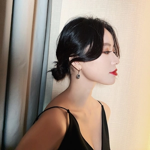 Close-up of elegant black circular drop earrings on model for a minimalist fashion look
