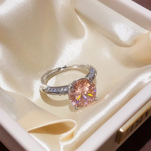 Close-up of champagne zircon ring with silver adjustable band in a jewelry box