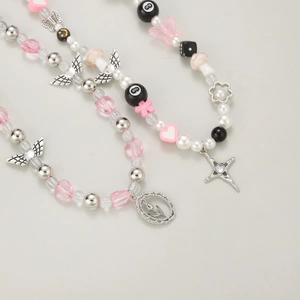 Detail of Y2K gothic necklace with pink butterfly, pearl beads, and metal star pendant