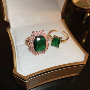 Detail view of emerald green stone ring set with rose gold finish in a luxury jewelry box