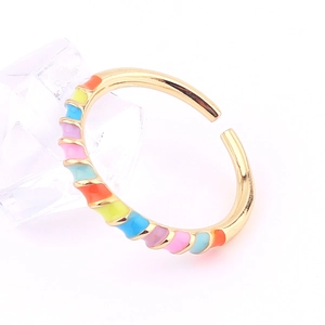 Close-up of golden adjustable ring featuring colorful enamel rainbow patterns on ice props