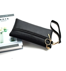 Detail of black double-zipper PU leather clutch with metal ring buckle and wrist strap