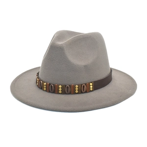 Detail of wool fedora hat featuring a brown leather band with shell and gold stud accents