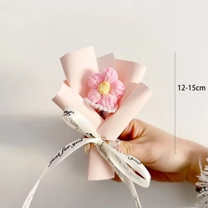 Close-up of a handmade pink crochet flower bouquet measuring 12-15cm with white ribbon