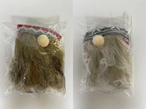 Detail of plush gnome bottle covers with long beards and knitted hats in plastic packaging