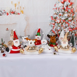 Golden sequin Christmas plush figurines of Santa and Reindeer on a white fireplace mantle