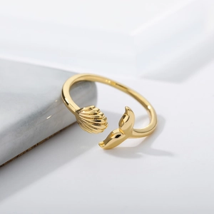 Macro detail of 18k gold plated whale tail ring with shell texture on marble