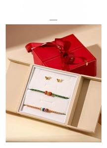 Close-up of beige jewelry gift box with velvet lining and butterfly earrings inside