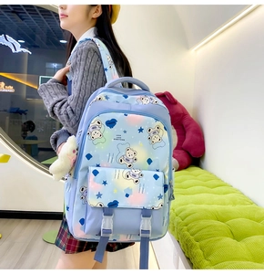 Side view of blue school backpack featuring cartoon bear print and secure buckle closure