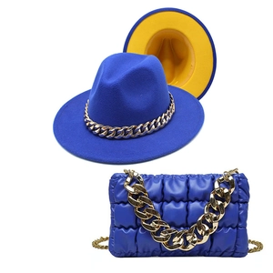 Detail of royal blue fedora with yellow lining and matching quilted bag with gold chains