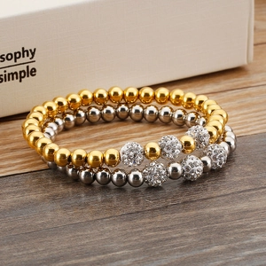 Detailed view of silver and gold beaded bracelets with crystal-encrusted accent spheres