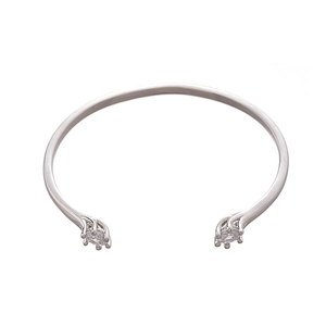 Silver open bangle with zircon stones on ends in a minimalist geometric design