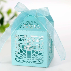 Detail of light blue hollow laser-cut cross candy box with matching silk ribbon bow