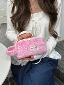 Close-up of pink leopard faux fur makeup bag with soft plush texture and side handle