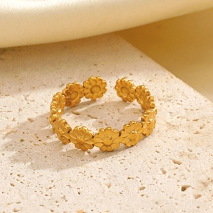 Chic golden stainless steel daisy ring with matte finish on a minimalist stone display