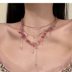 Detailansicht der mehrlagigen Blumen-Fransen-Halskette mit rosa Steinen am Modell