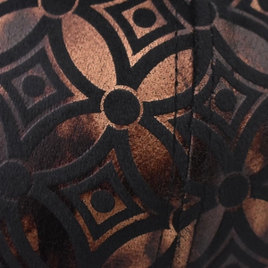 Close-up of thick plaid baseball cap with black geometric pattern on dark brown leather