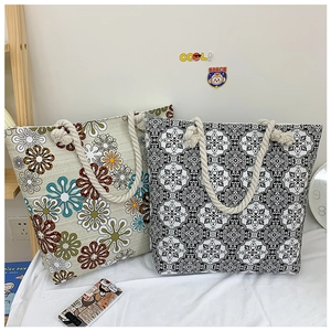 Detail of large canvas tote bags with floral and geometric prints and rope handles