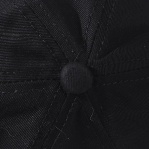 Detail of a black washed cotton baseball cap showing top button and six-panel stitching