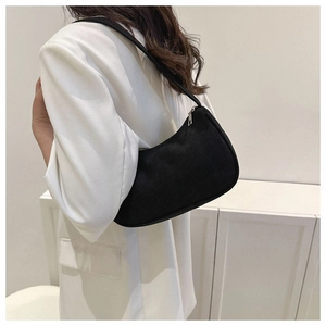 Minimalist black corduroy underarm bag shown on model against a white background
