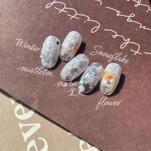 Translucent matte nail art tips with snowflake designs and tiny pearl accents