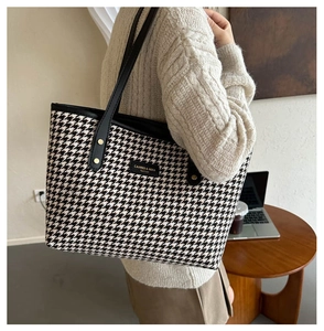 Lifestyle shot of large houndstooth tote bag on shoulder showing retro fashion texture