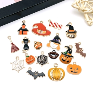 Flat lay of seventeen Halloween enamel charms featuring pumpkins bats and ghosts