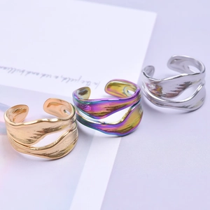 Detailed close-up of three lava texture adjustable stainless steel rings in gold, silver and rainbow