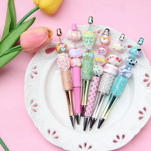 Set of 6 DIY beaded pens with colorful acrylic candy and ice cream beads on a white tray