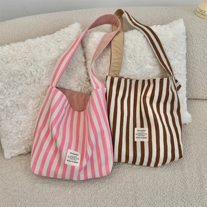 Primo piano di borse tote in tela spessa con strisce rosa e marroni e etichette cucite
