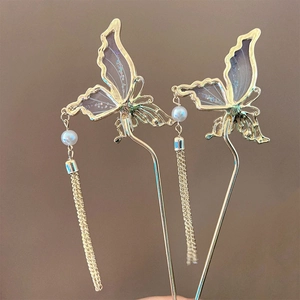 Détails d'épingles à cheveux papillon dorées avec ailes violettes, perles et glands