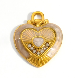 Macro detail of 18k gold plated heart pendant with beige enamel and clear crystal accents