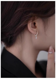 Close-up of 925 silver flower zircon drop earrings worn by a model in a cold-tone style