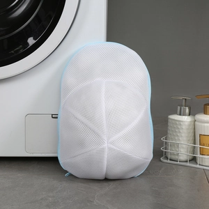 Mesh laundry bag for hats positioned next to a washing machine for anti-deformation care