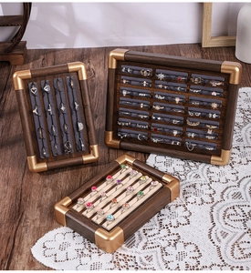 Detailed view of walnut wood jewelry display trays with velvet inserts and gold corners