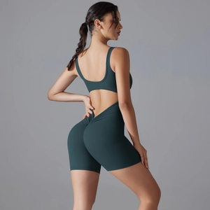 Detail of ruched peach-butt seam and open back on dark green yoga romper