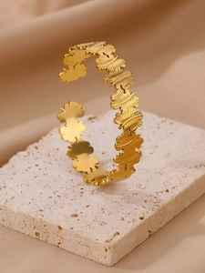Gros plan du bracelet jonc doré en acier inoxydable avec détails de papillons ciselés