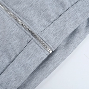 Gros plan détaillé d'une fermeture éclair en métal argenté sur un sweat à capuche gris chiné