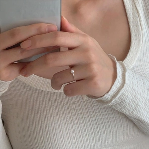 Close-up of elegant S925 sterling silver ring featuring a single white pearl on a hand
