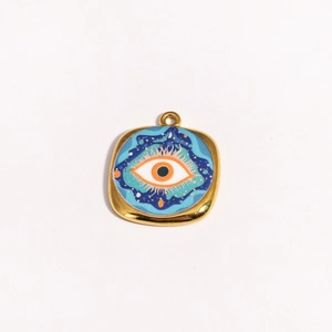 Detail view of a square gold evil eye pendant with blue and orange enamel star pattern