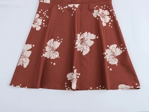 Gros plan du motif floral blanc sur tissu marron avec détails de l'ourlet à volants