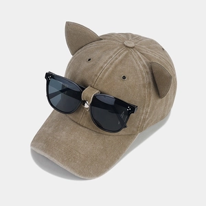 Dettaglio del cappellino da baseball kaki in pelle scamosciata con orecchie di gatto e occhiali