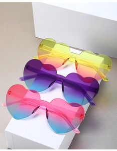 Three pairs of frameless heart-shaped sunglasses with vibrant gradient tinted lenses