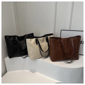 Retro color-block large tote bags in black, cream, and brown displayed on white stairs