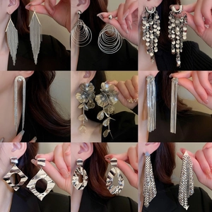 Nine-grid display of silver oversized floral tassel and geometric fringe drop earrings