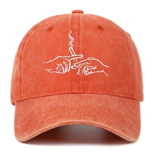 Close-up of vintage washed orange baseball cap featuring hand-embroidery on the front