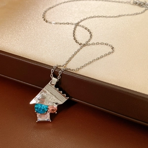 Makroaufnahme von Silber-Bonbon-Anhänger mit bunten Strasssteinen auf Satinhintergrund