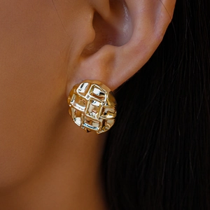 Gros plan de boucles d'oreilles rondes dorées avec une texture vintage ciselée